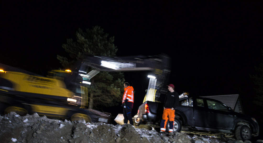 Bil, folk og gravemaskin