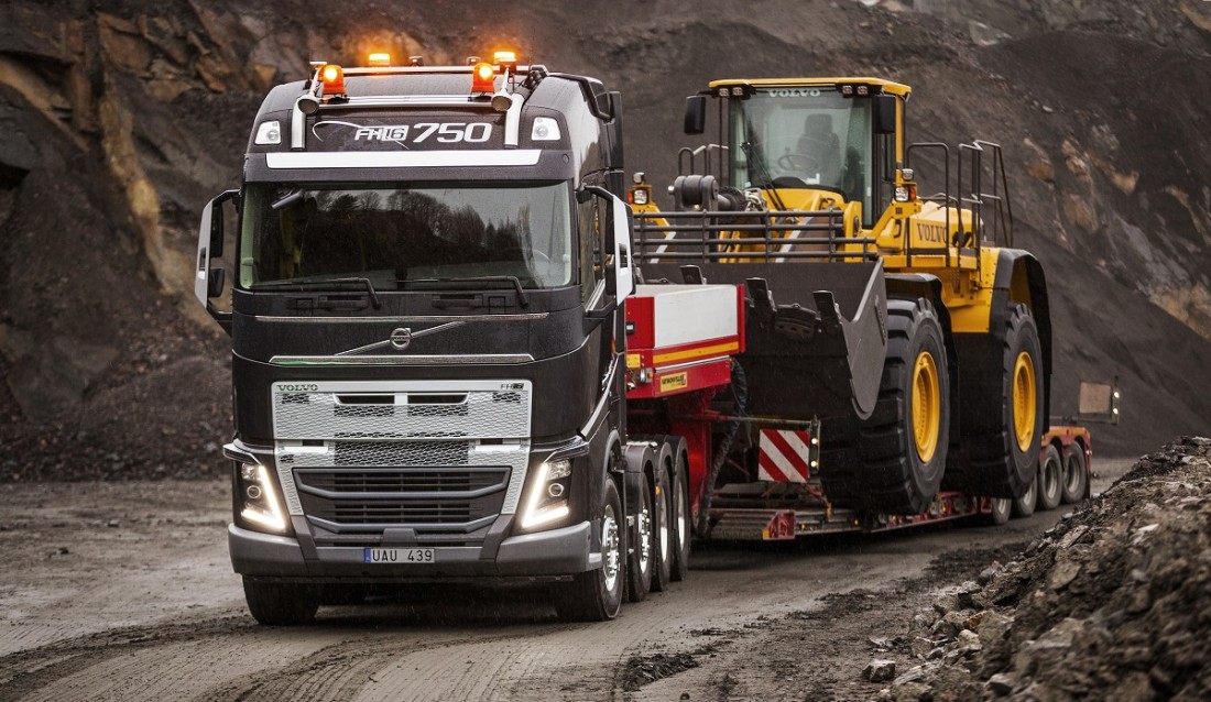 Volvo FH tungtrekker med hjullaster på henger.