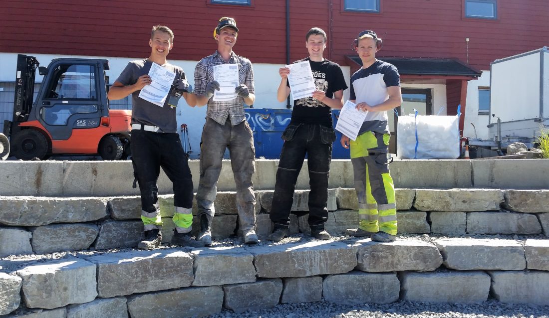 På amfiet de selv har murt: Trym Dinessen, Pål Andreas Kolås, Anders Revheim Johansen og Andreas Rysjedal Kvamme, alle med lærekontrakten i hånden. Alle hadde fått læreplass før skoleavslutningen. (Foto: Stian Eikevik).