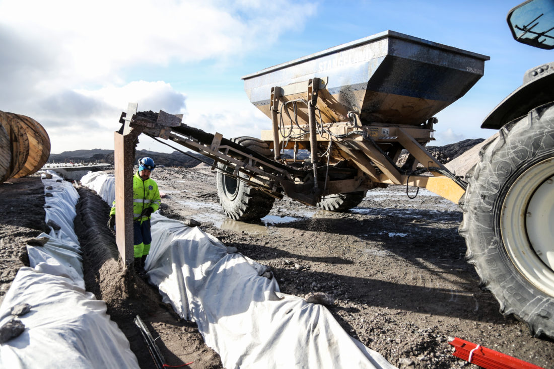 Det bygges omtrent like mange kilometer med kabelgrøfter som det bygges vei. Her blir det fylt på med sand over høyspentledningene som er lagt ned. I bakgrunnen skimtes betongfundamentet. (Foto: Runar F. Daler).