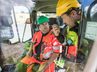 Maskinfører Hans Petter Myhrer får en innføring av Fredrik Sætren. Dette er den første hjullasteren Cat leverer med firepunkts sikkerhetssele.