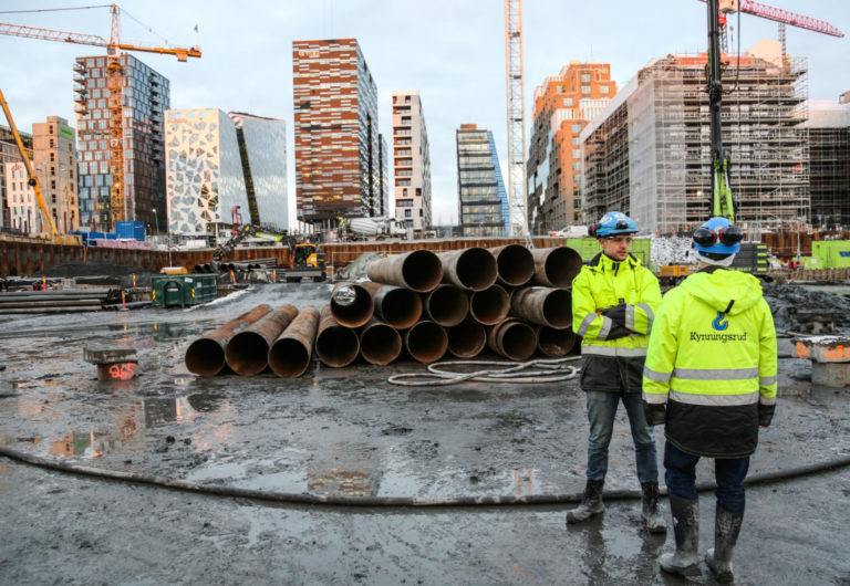 – Det bygges på gammel sjøbunn, og det er litt av bakgrunnen for løsningen med omstøpningsrørene, forklarer Kynningsruds anleggsleder Marius Østberg Olsen: Her sammen med prosjektleder Per Gunnar Davidsen (med ryggen til) foran noen av omstøpingsrørene. I bakgrunnen er den velkjente barcode-rekka. (Foto: Runar F. Daler).