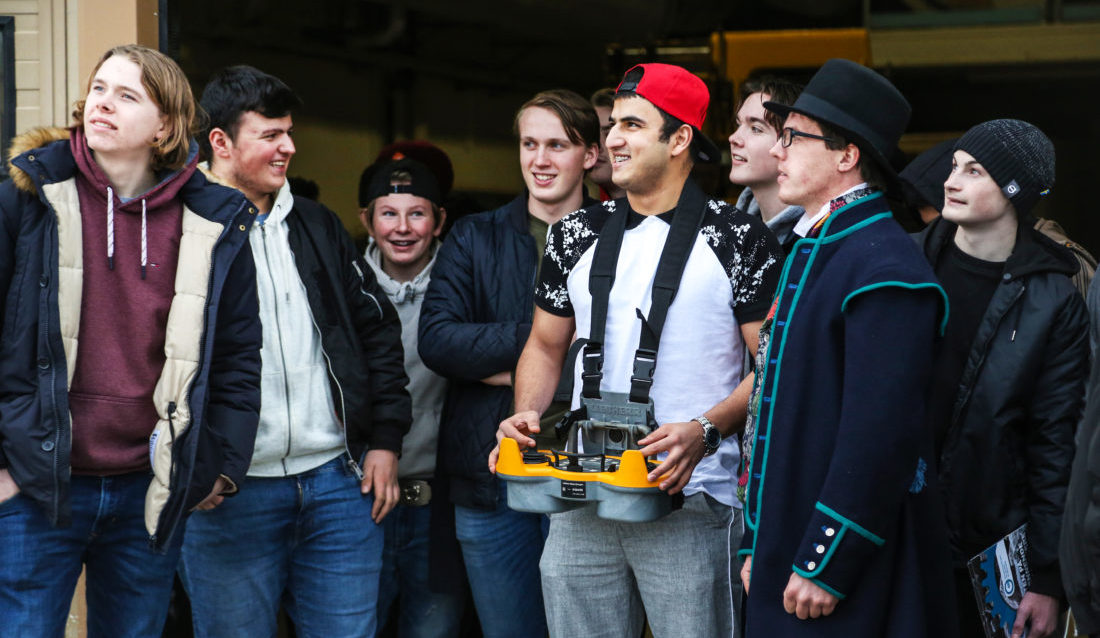 FIKK PRØVE SEG: Zahidullah Zarghon (18) fra Greåker vgs. får prøve og styre den store mobilkranen som Sarpsborg-entreprenøren Fosby AS stilte med på messen. De andre elevene følger spent med. (Foto: Runar F. Daler).