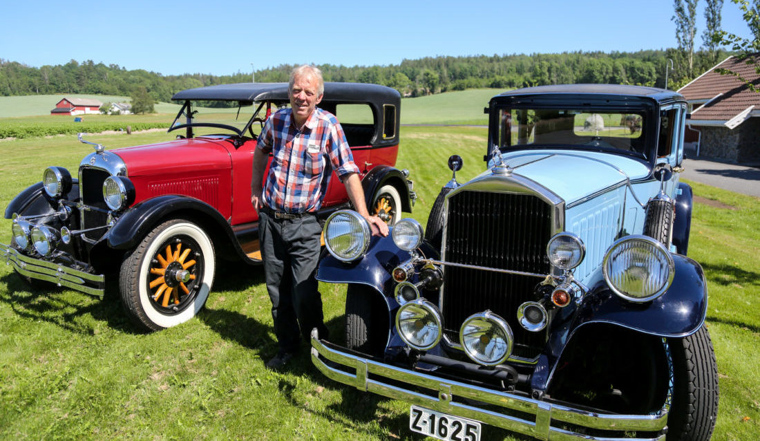 CAR ENTHUSIAST: Ole Martin Manvik has an impressive collection of old cars on his farm on the southern coast of Norway. Here, a Pierce Arrow 1929 model (in front). 8 cylinders, 125 horses, 6 litres. The car is partially restored and is a favourite among newly- weds. Behind Manvik , a Studebaker 1925 model. It is partially restored and was, according to Manvik, a favorite among the police in the 1920s in the US. (Photo: Runar F. Daler).