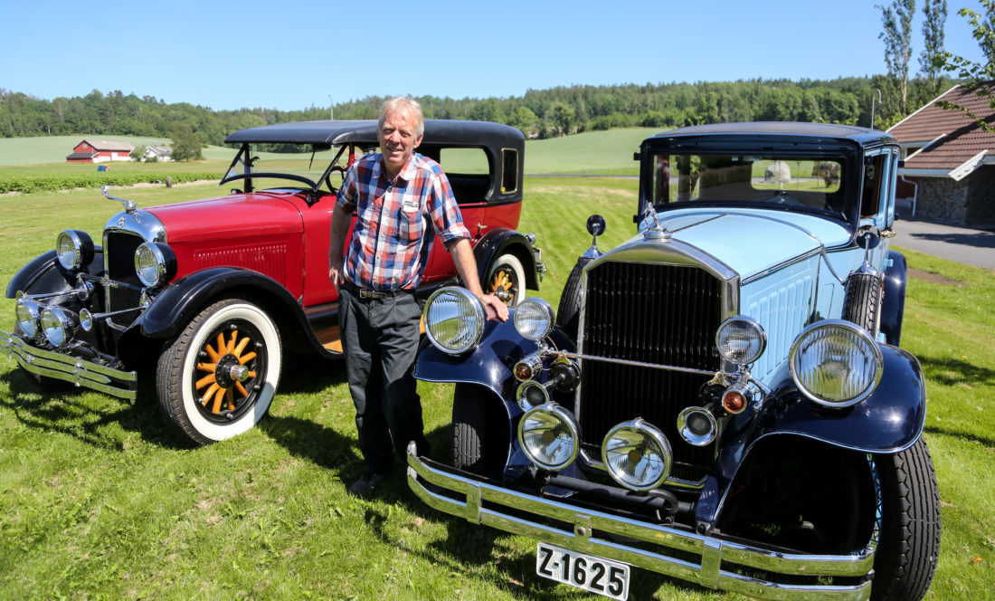 CAR ENTHUSIAST: Ole Martin Manvik has an impressive collection of old cars on his farm on the southern coast of Norway. Here, a Pierce Arrow 1929 model (in front). 8 cylinders, 125 horses, 6 litres. The car is partially restored and is a favourite among newly- weds. Behind Manvik , a Studebaker 1925 model. It is partially restored and was, according to Manvik, a favorite among the police in the 1920s in the US. (Photo: Runar F. Daler).
