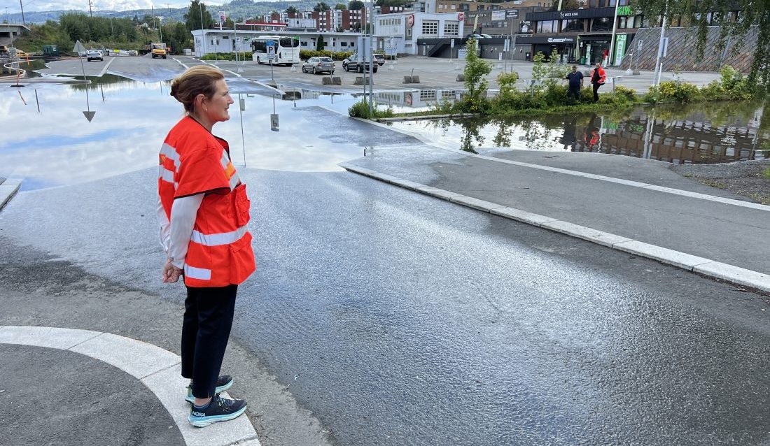 En sterkt preget veidirektør Ingrid Dahl Hovland ser på skadene ekstremværet Hans har forårsaket på Gjøvik. (Foto: Erik Larsstuen/Statens vegvesen)