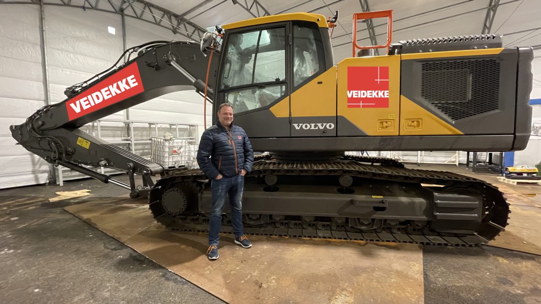 Kristian Sabel, fagansvarlig grunn og masseflytting i Veidekke Anlegg, foran det som blir den første hydrogendrevne gravemaskinen fra Applied Hydrogen. (Foto: Veidekke)