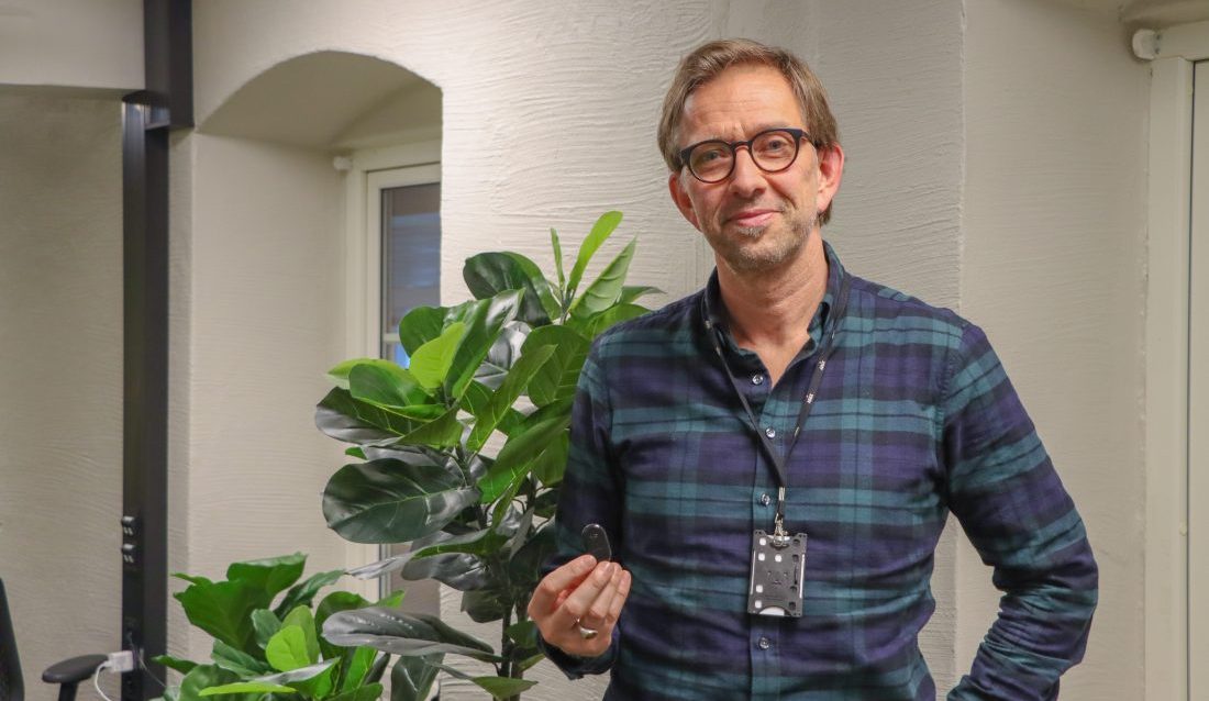 Bruce Atle Karlsen, CPO hos Abax, forteller at selskapet de senere årene har utviklet tjenestespekteret rundt den elektroniske kjøreboka som selskapet er mest kjent for, og viser oss sporingsenheten Mini2. (Foto: Njål Hagen)