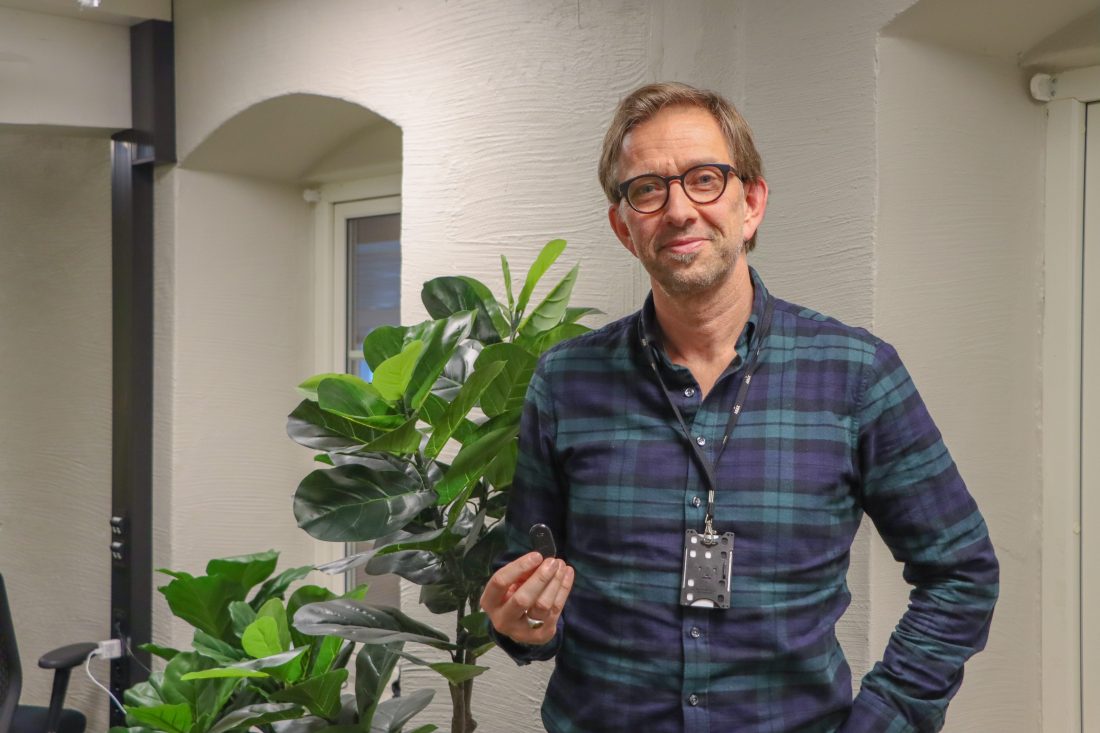 Bruce Atle Karlsen, CPO hos Abax, forteller at selskapet de senere årene har utviklet tjenestespekteret rundt den elektroniske kjøreboka som selskapet er mest kjent for, og viser oss sporingsenheten Mini2. (Foto: Njål Hagen)