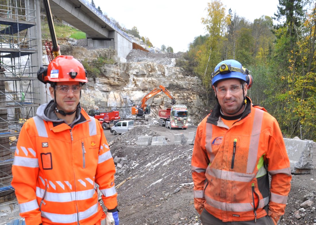 Geir Brevik i Statens vegvesen (t.v.) og Mario Mühlmann i Norsk Bergsikring (NBS), vurderer sikringsbehovet i skjæringen ved Isi bruer i bakgrunnen. (Foto: Kjell Wold)