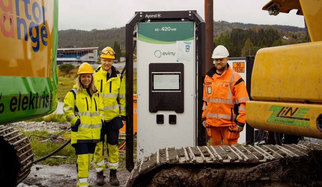 Med flere tunge, elektriske anleggsmaskiner på byggeplassen øker behovet for raske ladeløsninger. F.v. Camilla Moster, leder for Mobil energi i Eviny, Jørgen Alvheim, teknisk prosjektleder for Mobil energi i Eviny og Thomas Tyssøy, maskinfører i Sartor & Drange. (Foto: Eyvind Bohne-Kjersem, Eviny)