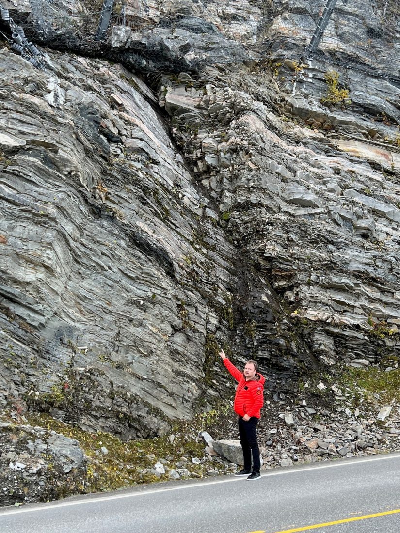 Her gikk raset som tok seg over skredsikringen. Sven Ingvar Hoel Larsen peker mot skredsikringsnettet som er fullt av stor stein som er kommet ned fjellsiden. (Foto: privat)