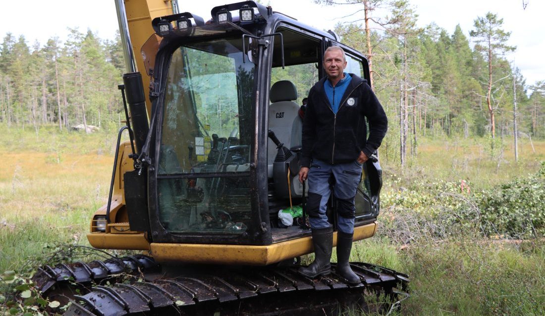 Tommy Mellemstuen, i Tronfjell Maskin, utfører arbeidet med å tette dreneringsgrøfter på myrene på Finnskogen, tett på svenskegrensa. (Foto: Njål Hagen)