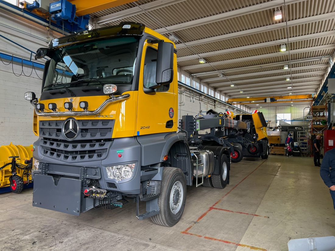 Inne i hallene hos Øveraasen på Gjøvik er det mye utstyr som skal ut før vinteren. Her en sope og blåsemaskin bygget på en Mercedes Arocs 2042. (Foto: Njål Hagen)