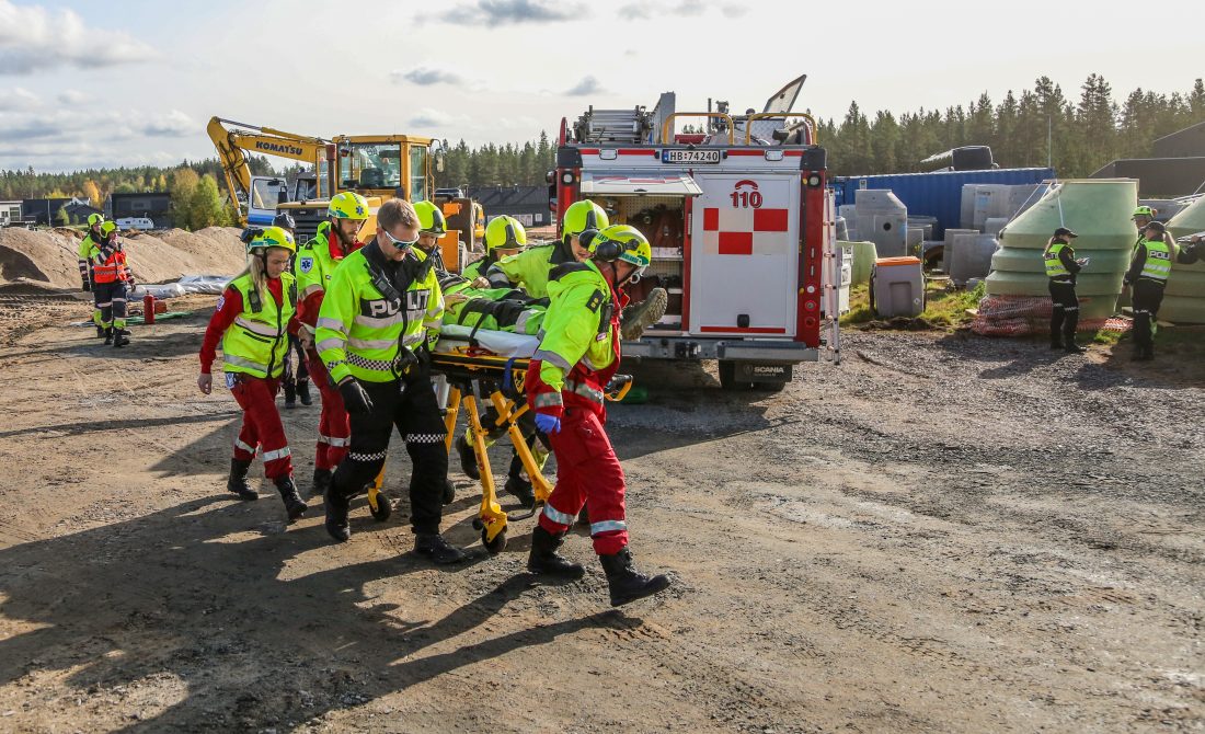 SKADET: Omsider blir den «skadde» passasjeren fraktet ut av lastebilen og til en ventende ambulanse.(Foto: Runar F. Daler)