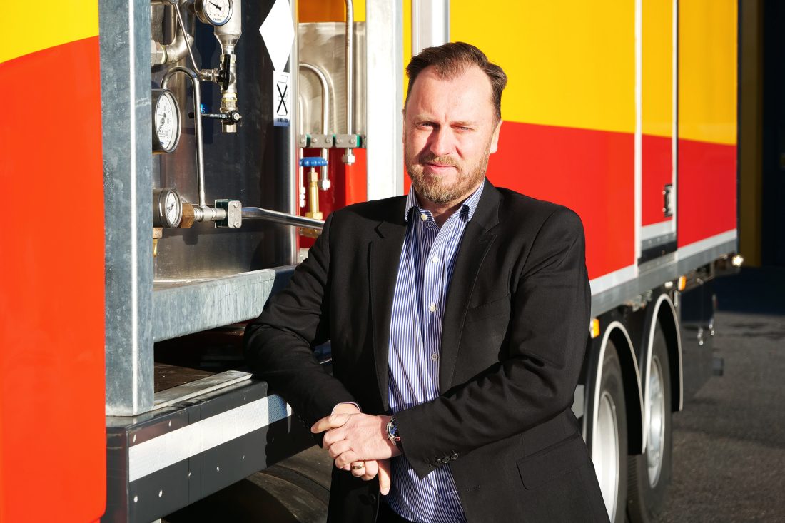 Adm. dir. Geir Jensen i Olimb Rørfornying AS foran biogass-tanker til steamgenerator og strømgenerator. (Foto: Olimb Rørfornying AS)