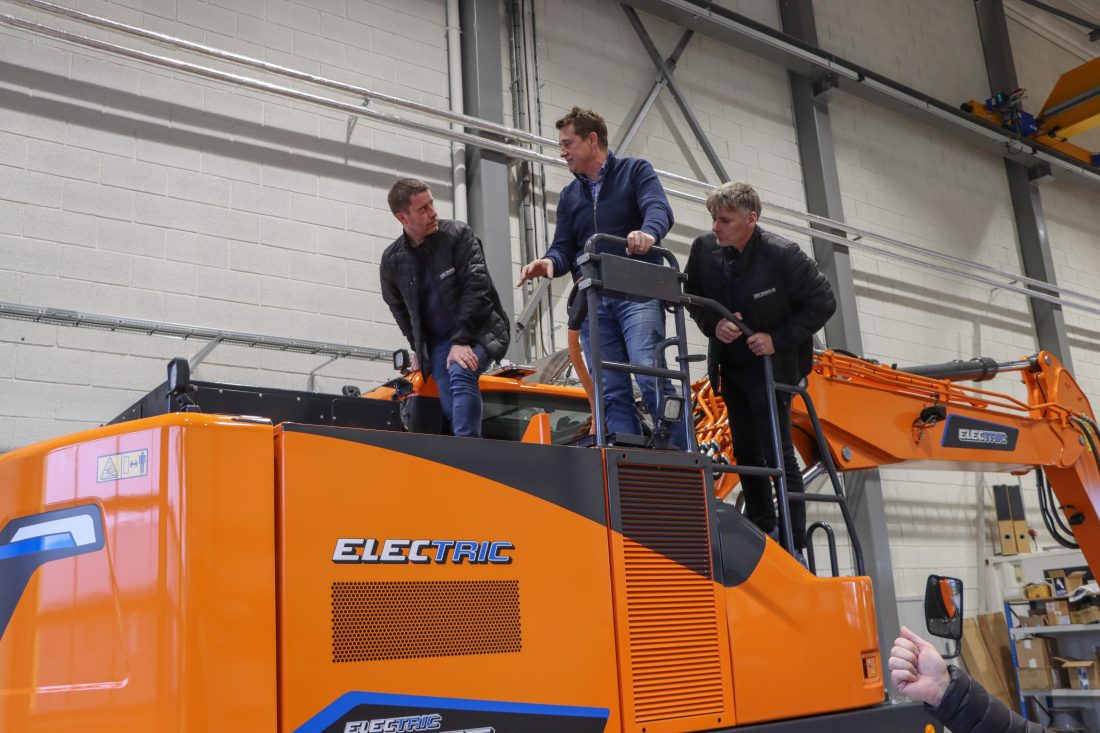 Tor Anders Høgaas, daglig leder i Rosendal Maskin, viser frem batteripakken og el-komponenter til Trygve og Frank Småge. (Foto: Njål Hagen)