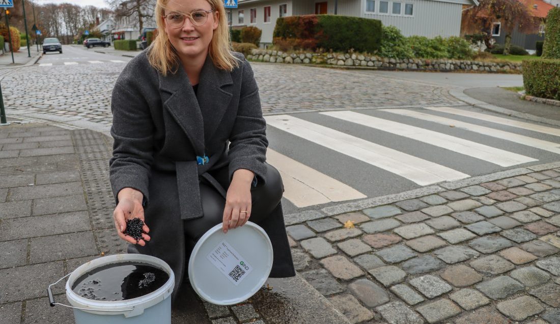 Siri Galland Grønli, daglig leder i Gind AS, med en 15-liters bøtte med selskapets partikkelbaserte fugemasse av bitumen. (Foto: Njål Hagen)