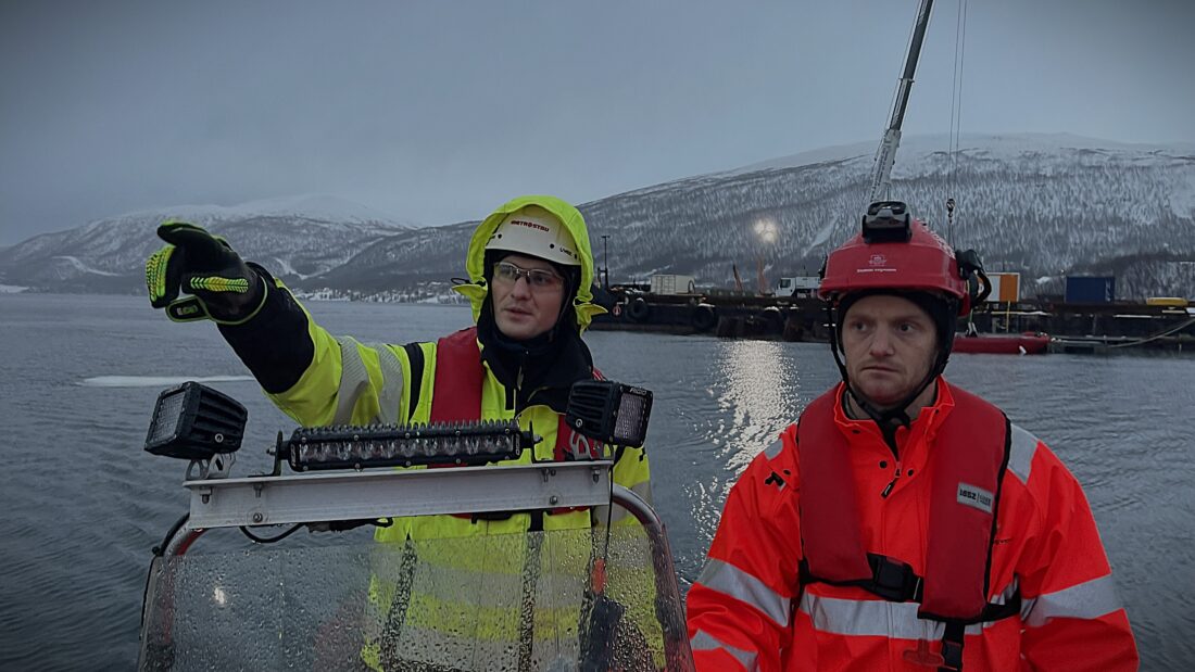 Produksjonsleder i Metrostav Norge AS, Tomas Haluza (t.v.), og teknisk byggeleder i Statens vegvesen, Sindre Vaaje, inspiserer arbeidet med pelene i de fem sjøkassene fra båt. (Foto: Knut Haarvik/Statens vegvesen)