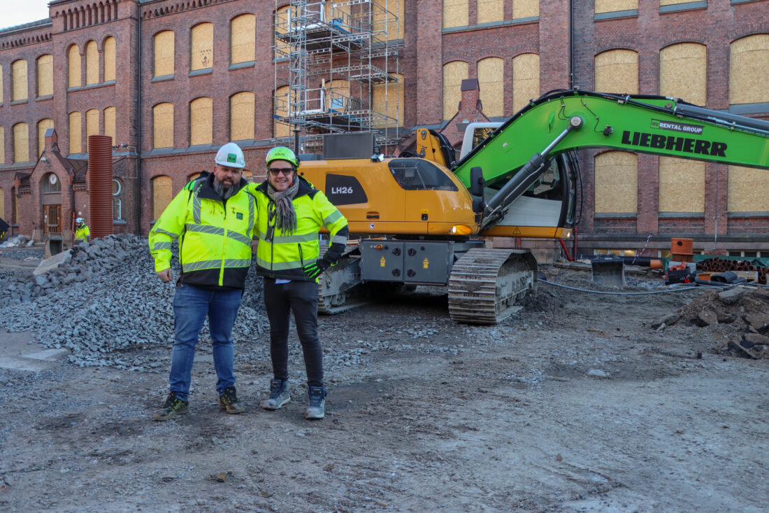 Stephan Karlsen (t.h.), prosjekt- og anleggsleder hos U.Reist, og Magnus Andreassen, salgsansvarlig hos Rental Group, foran den kabelelektriske Liebherr-graveren som er én av flere utslippsfrie maskiner på prosjektet med å rehabilitere Lilleborg skole. (Foto: Njål Hagen)
